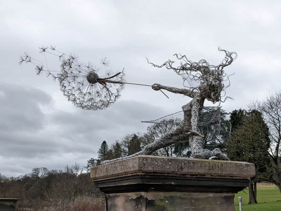 Fairy sculpture holding a dandelion