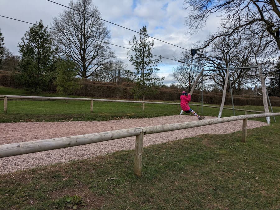 Child in a pink coat on a zip wire