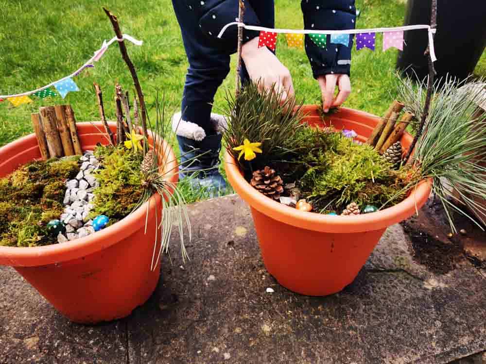 Two planters with mini gardens in with bunting
