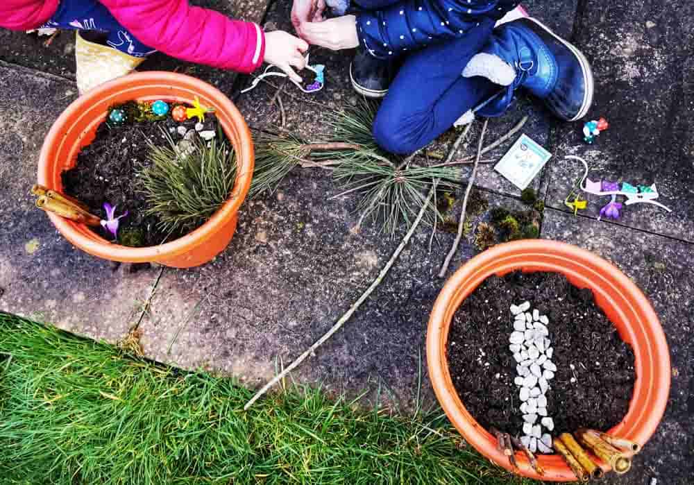 Two planters with kids creating mini gardens in them