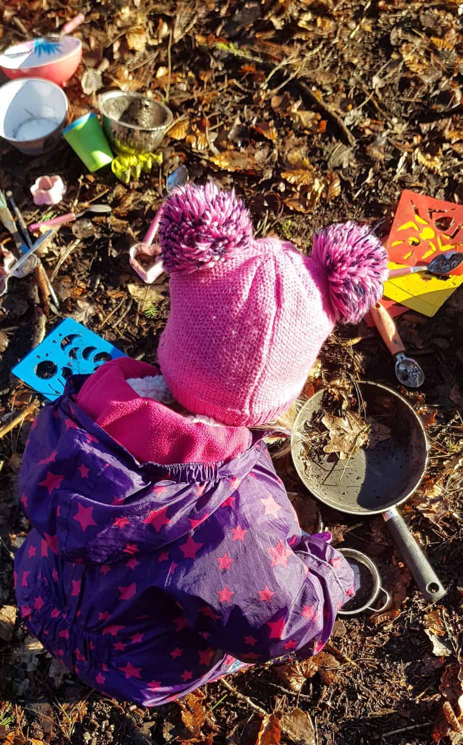 toddler in mud kitchen