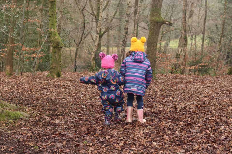 2 children running in the woods