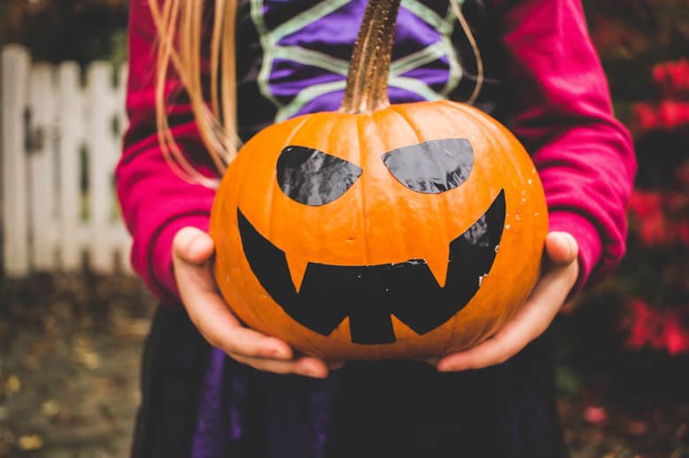Child holding a Halloween pumpkin