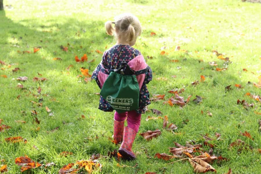 Toddler with seekers bag on her back