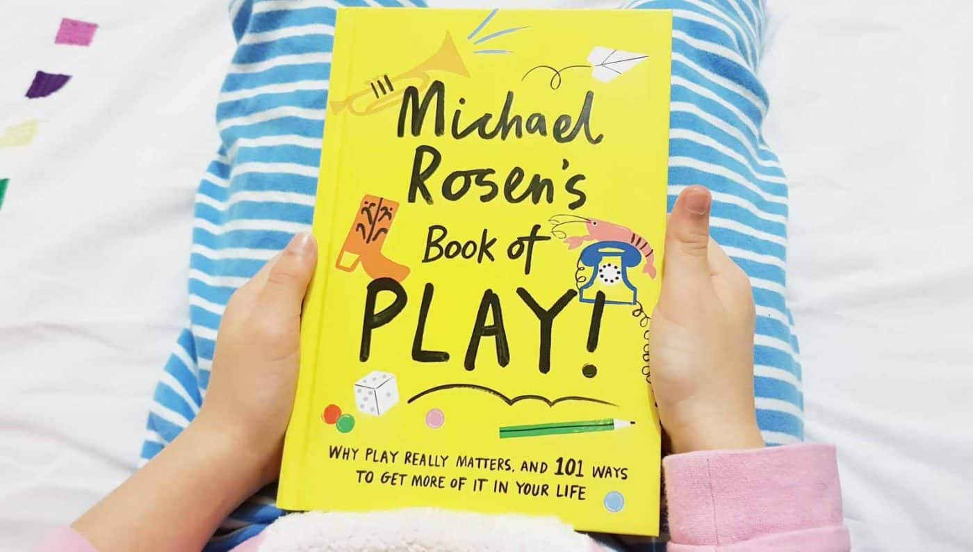 Child holding a yellow book, cover facing up