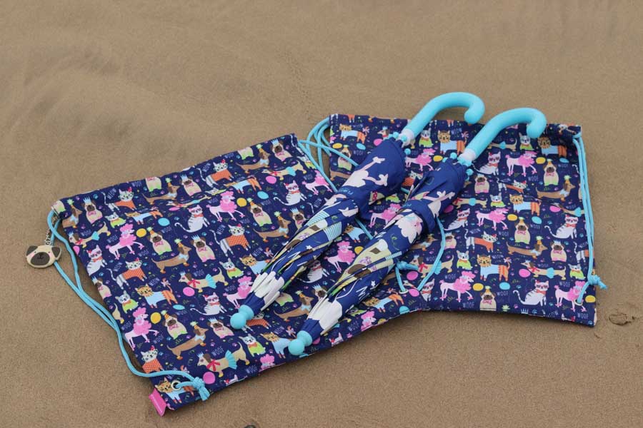 2 floss and rocks kit bags and umbrellas on the beach