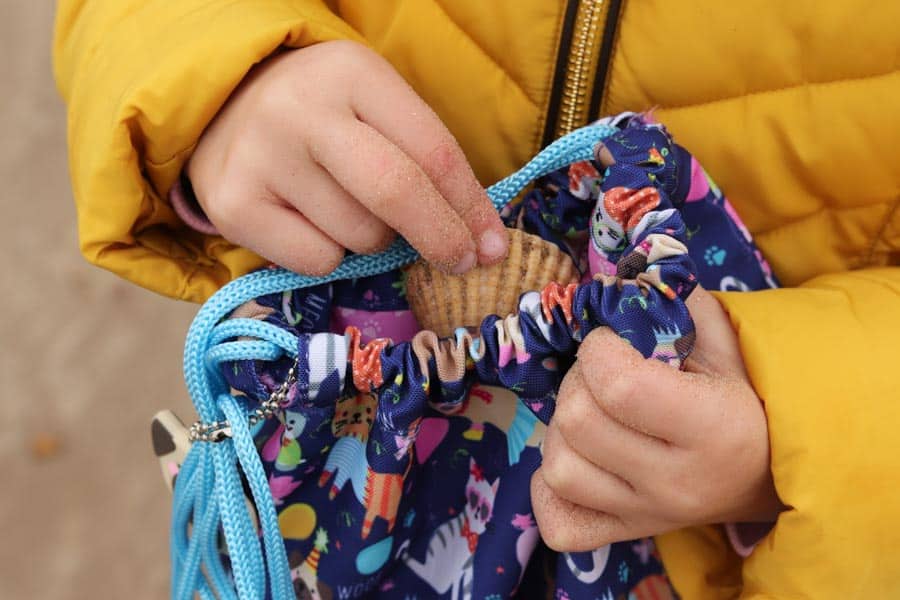 Hand putting shell in kit bag