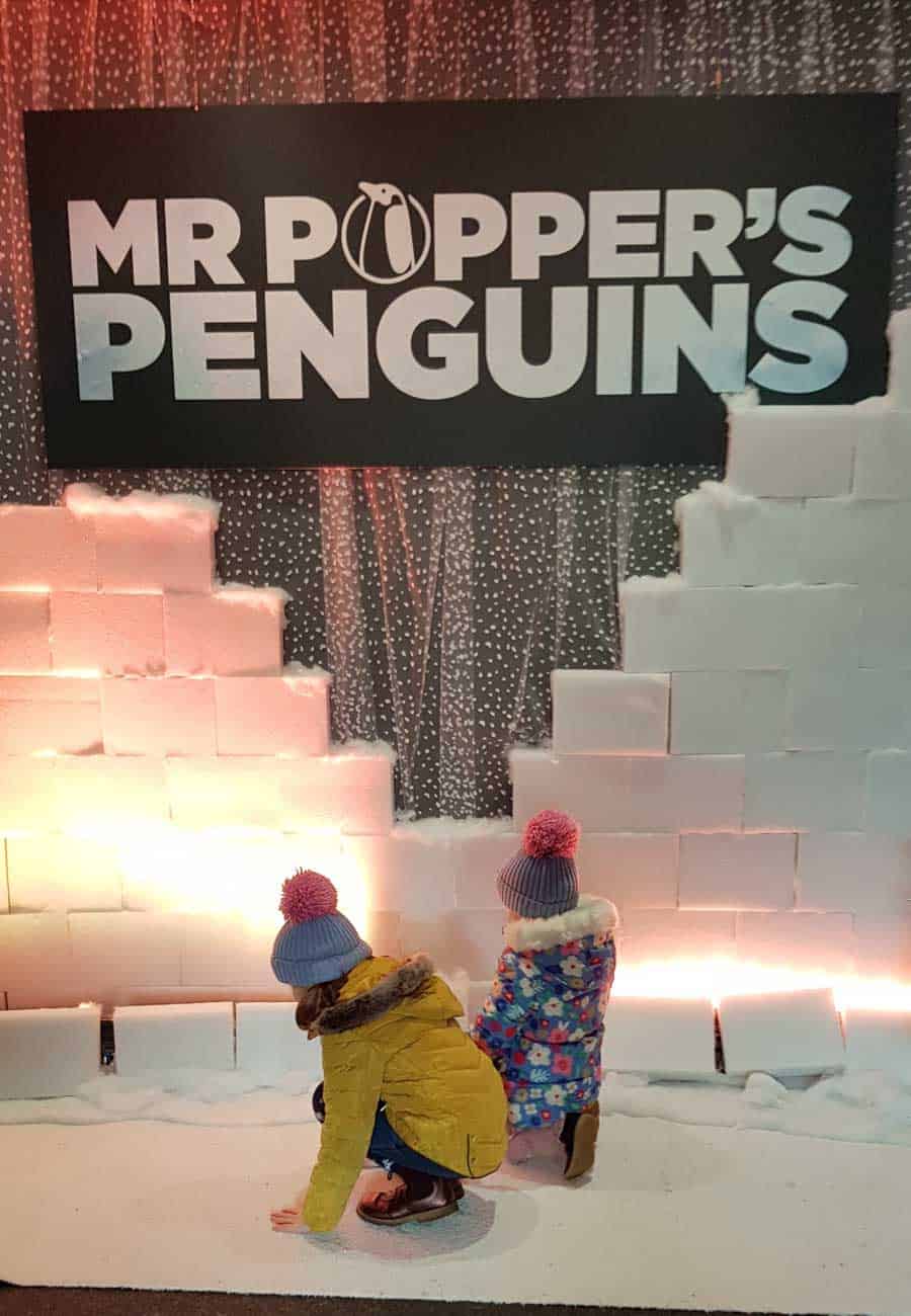 2 little girls in front of Mr Popper's Penguins set