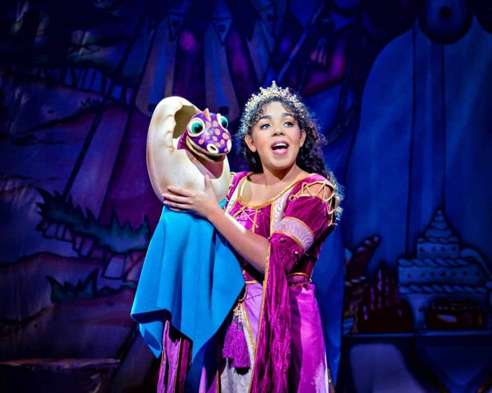 Princess and a baby dragon on stage in Sleeping Beauty at 