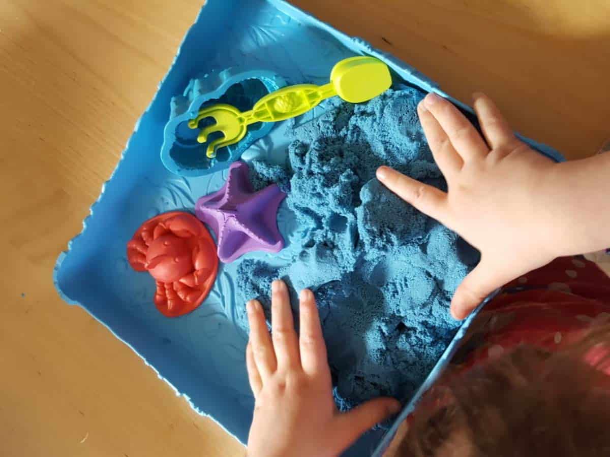 Childs hands and kinetic sand