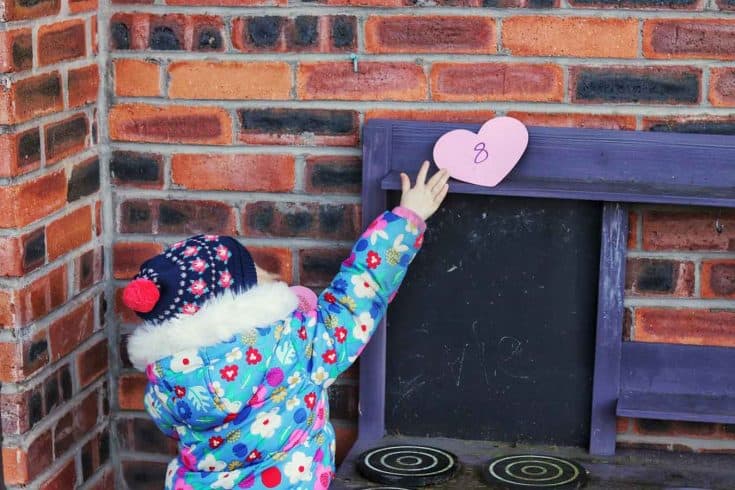 Preschooler reaching to collect a heart with a number on it