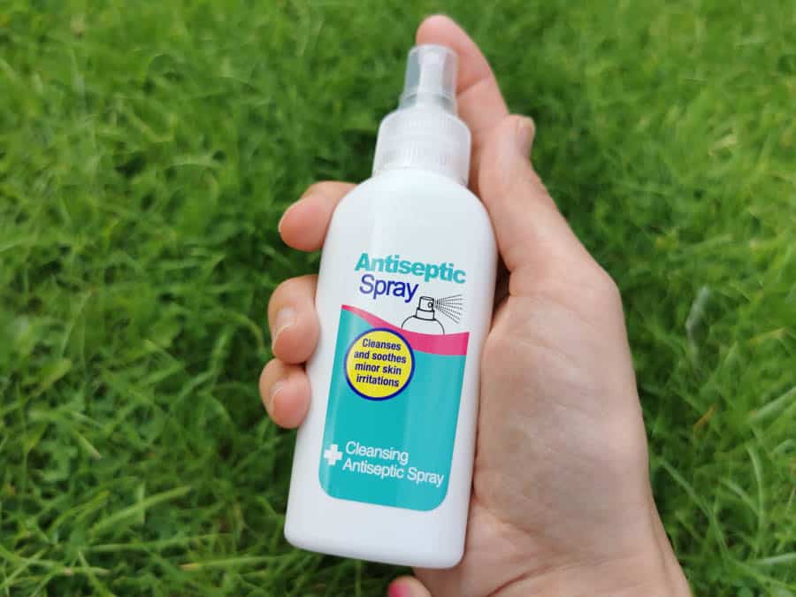 Hand holding a bottle of antiseptic spray