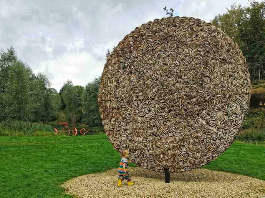 child by huge circular sculpture
