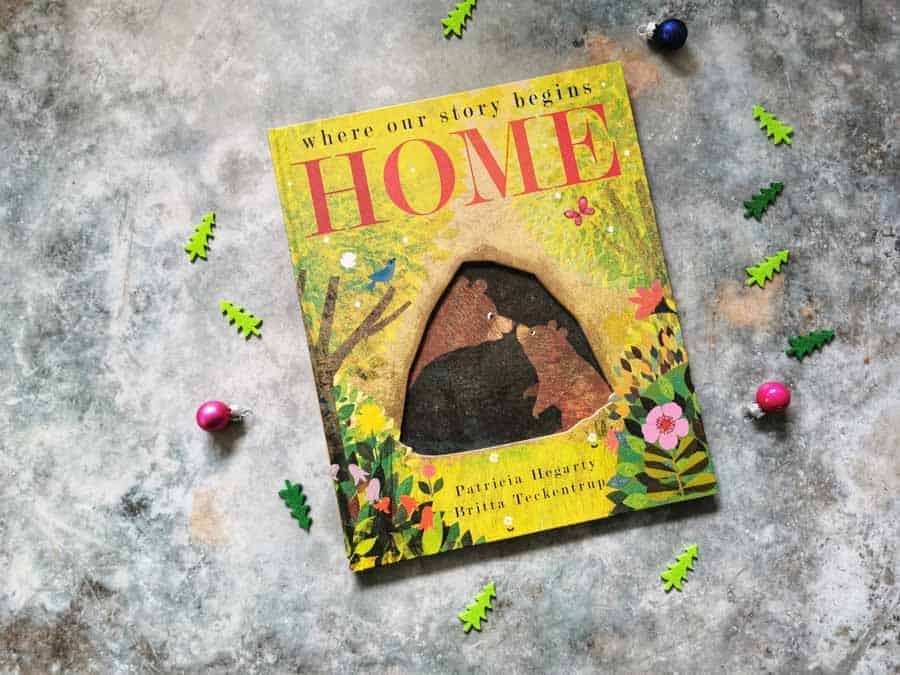 Front cover of the book home on a stone background with mini christmas decorations