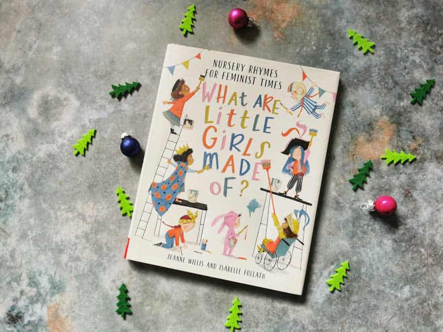 Front cover of the book what are ittle girls made of on a stone background with mini christmas decorations