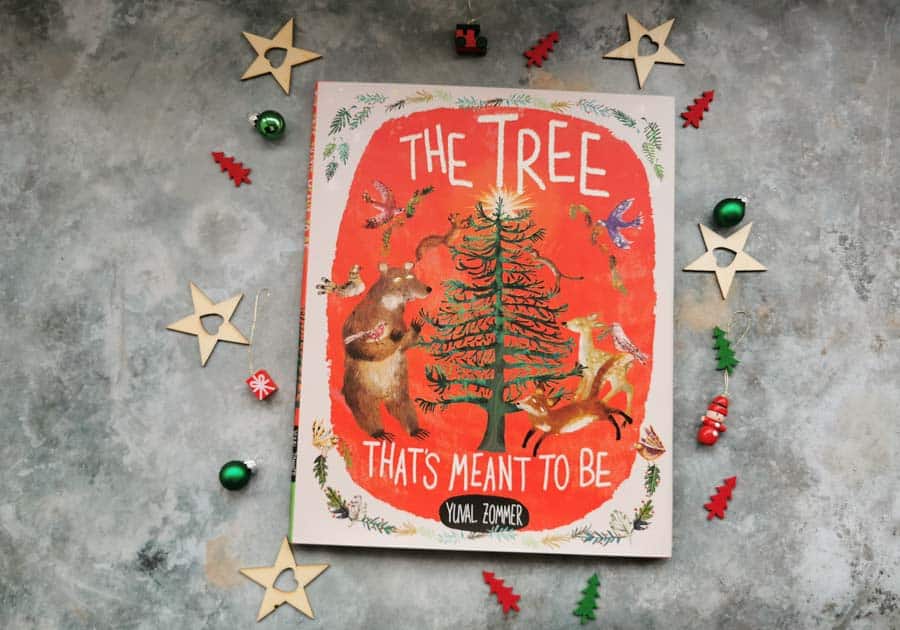 Copy of the tree that's meant to be childrens book on a stone background with mini christmas decorations surrounding it