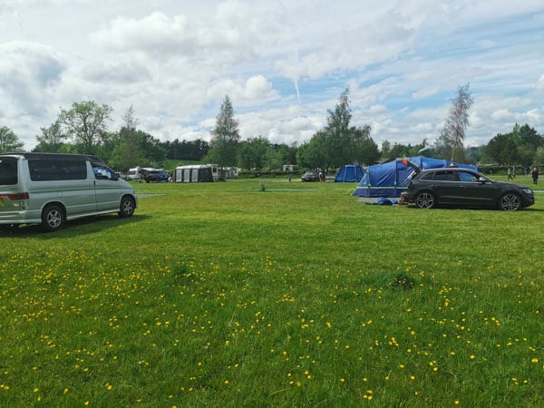 tents and campervans in a meadow