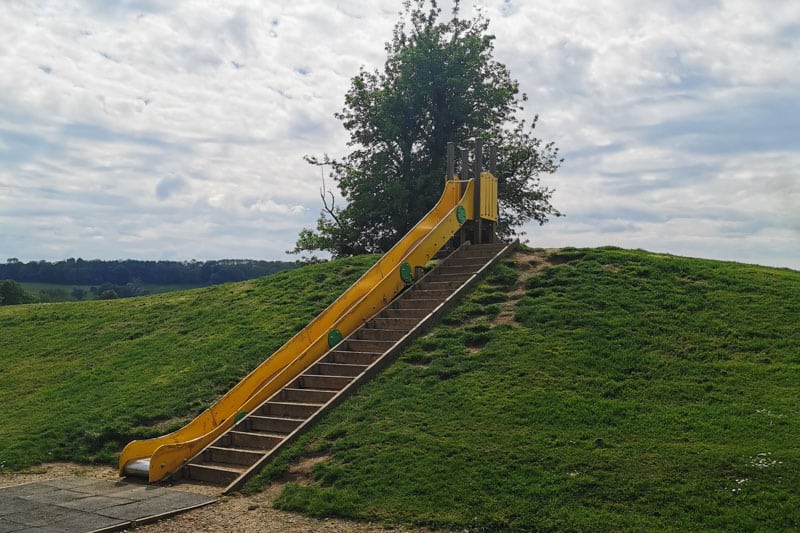 Yellow slide set into hill at Broadway Activity park