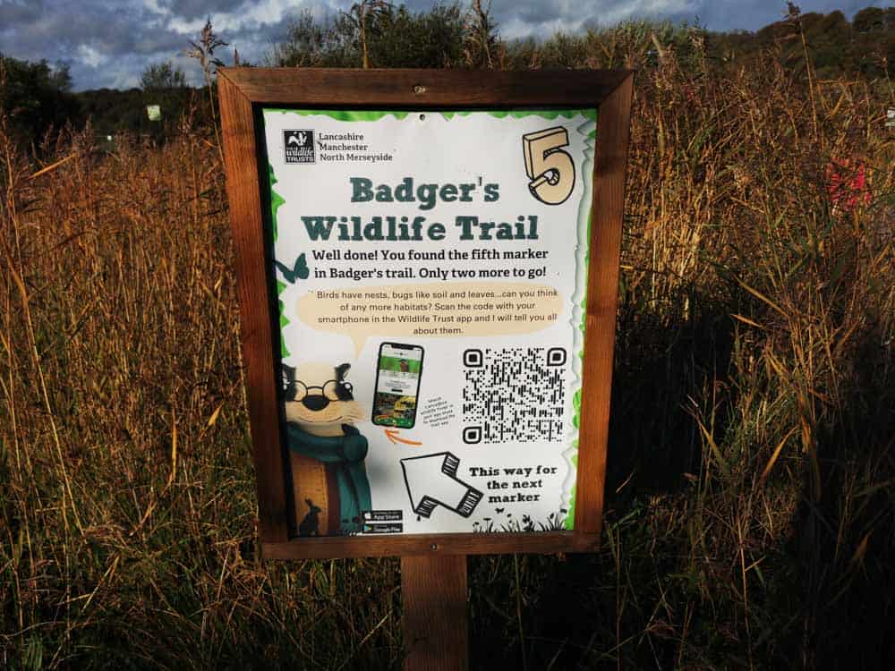 Board with information in a field of long grass
