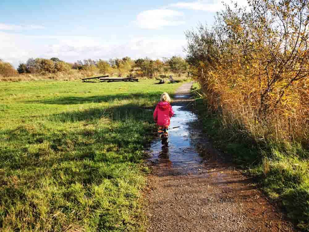Child running through puddle over path