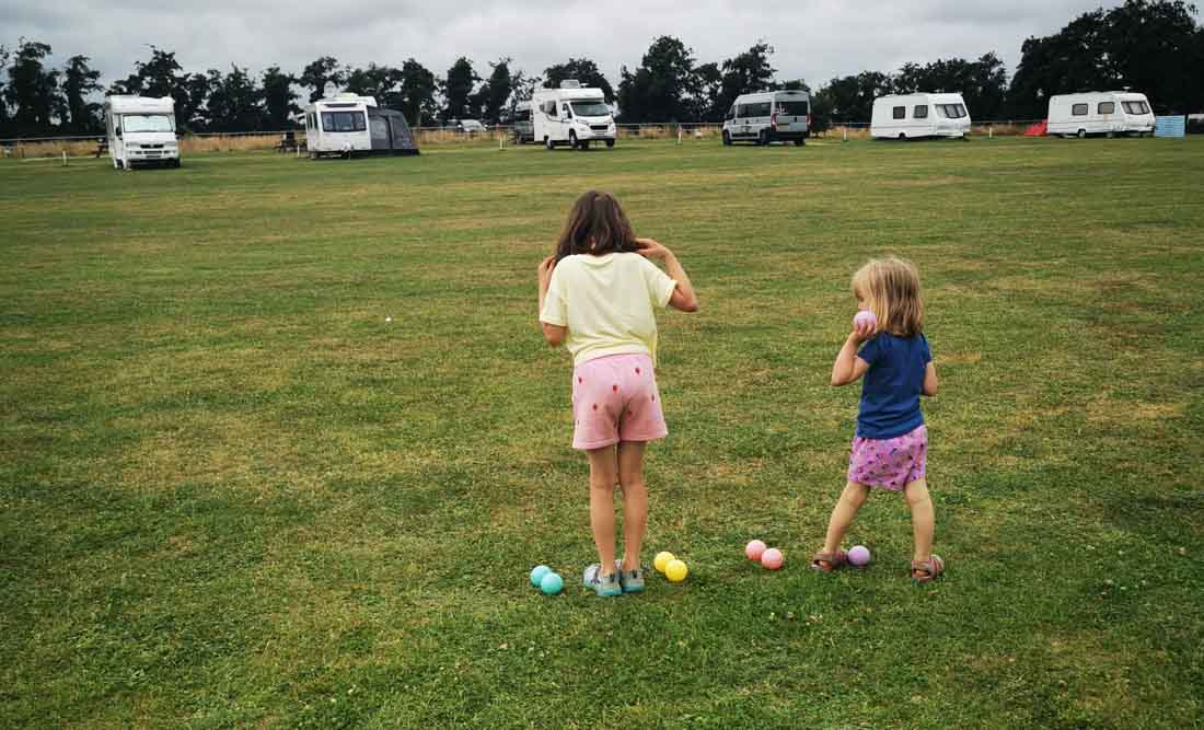 2 kids on a campsite playing boules