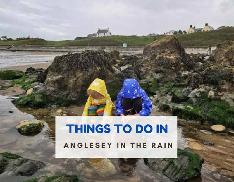Two children in rain coats at the beach and text that says things to do in Anglesey in the rain