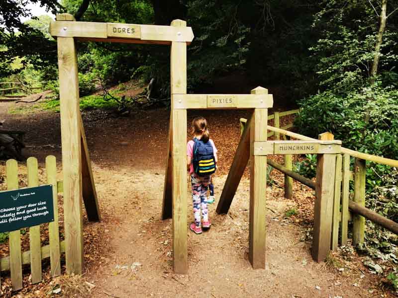 Child walking through a wooden arch