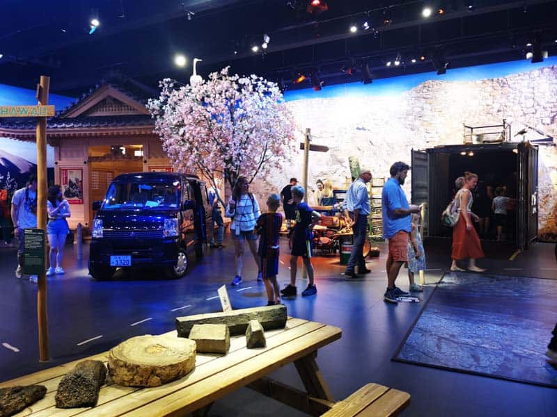 Inside a gallery with a cherry blossom tree and campervan