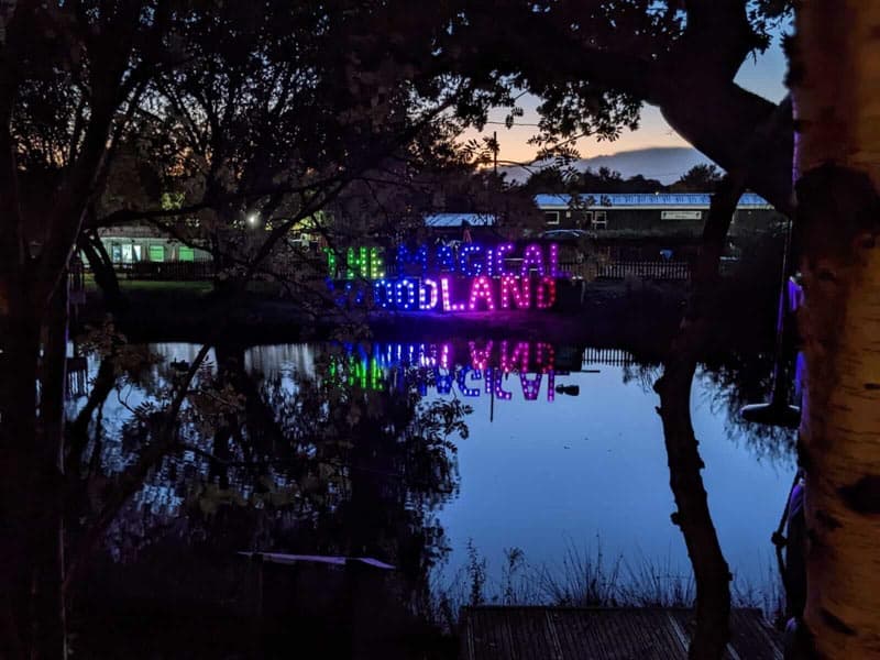 Magical woodlands light sign on a lake