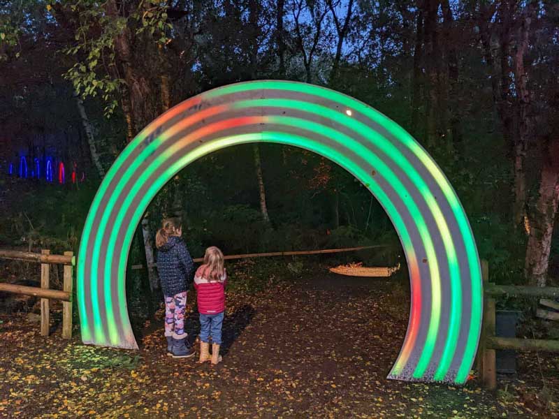 Children stood under a rainbow archway