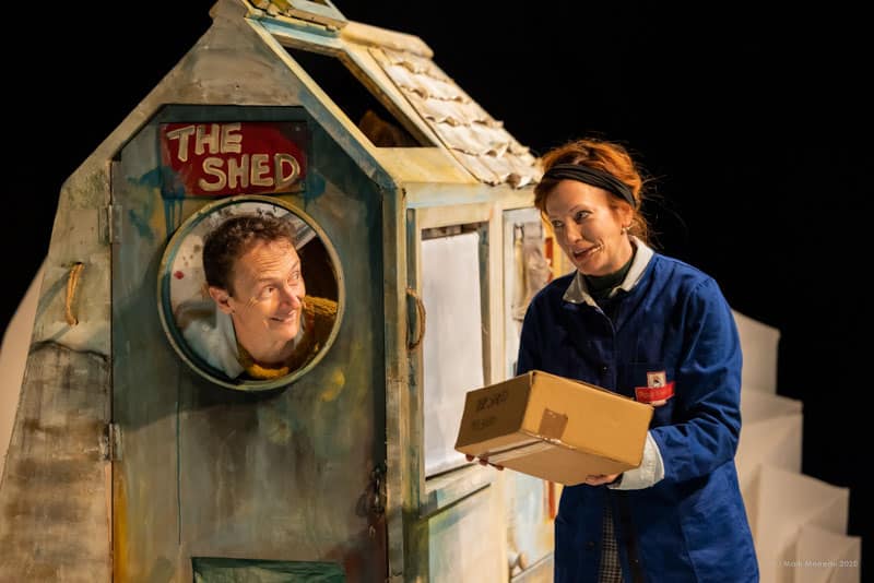 Man in a shed and lady bringing him a parcel