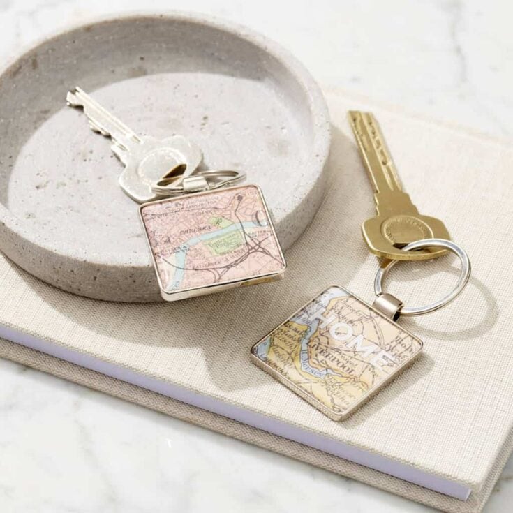 Keys on a chain with a vintage map keyring in a white bowl