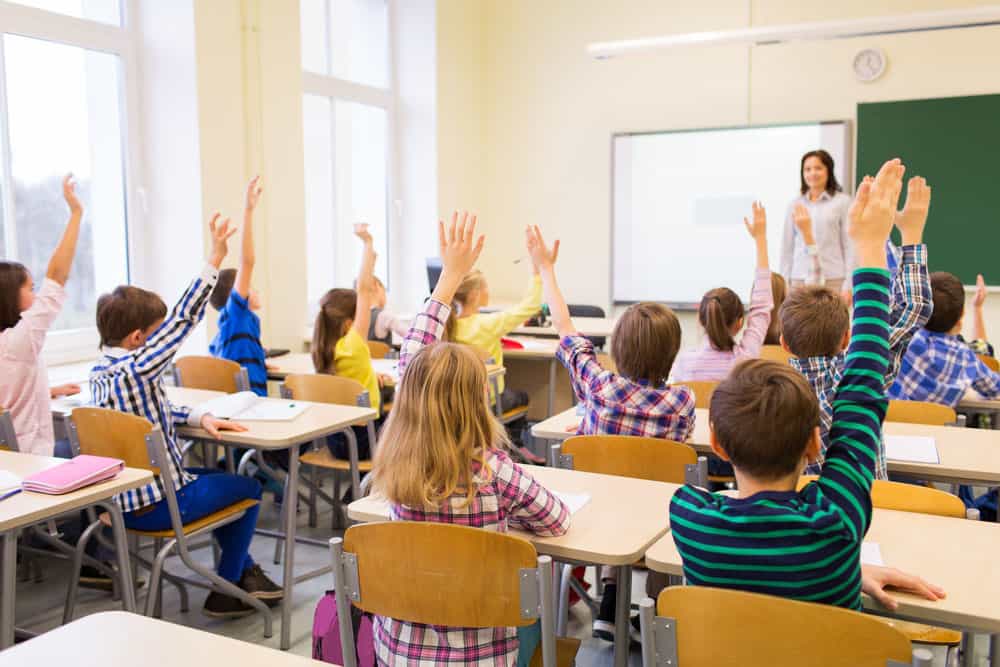 Classroom with kids hands raised