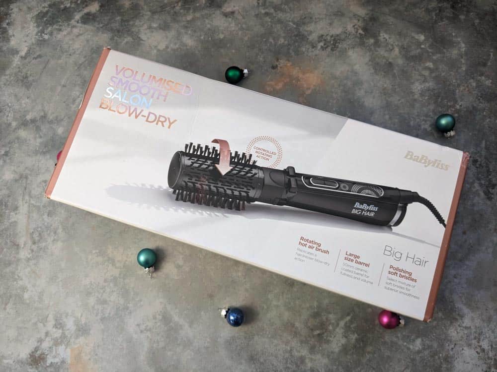 Boxed hair styler on a stone surface surrounded by mini baubles