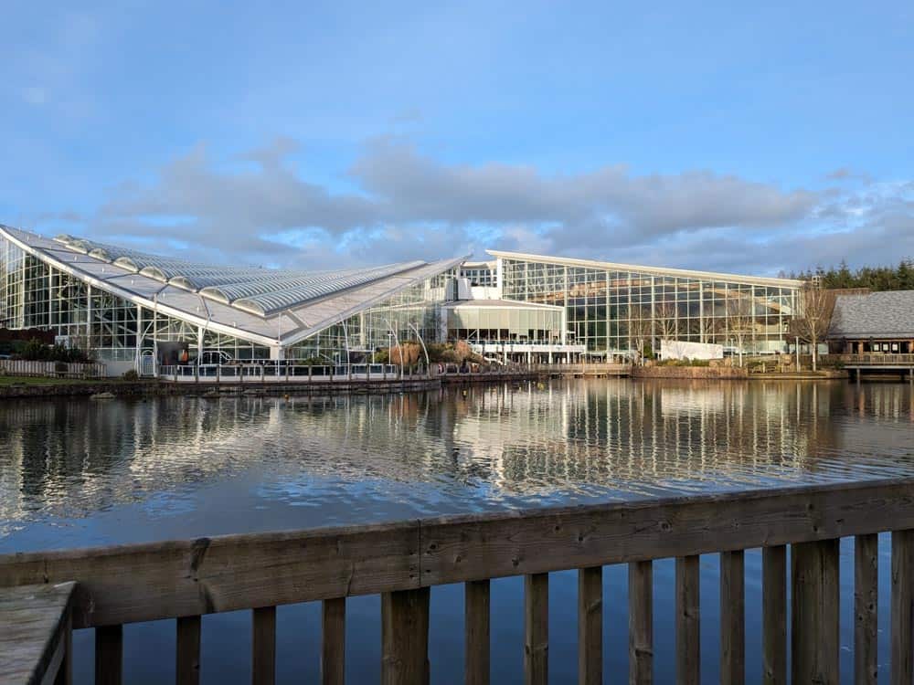 large glass domed building across a lake