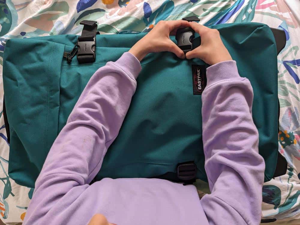 Child's hands closing a suitcase
