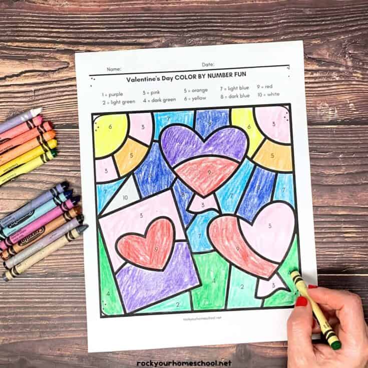 coloring in sheet that has been coloured and lots of crayons at the side