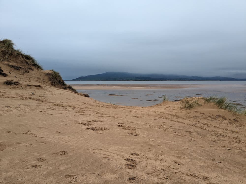Beach with sea and then land in the background