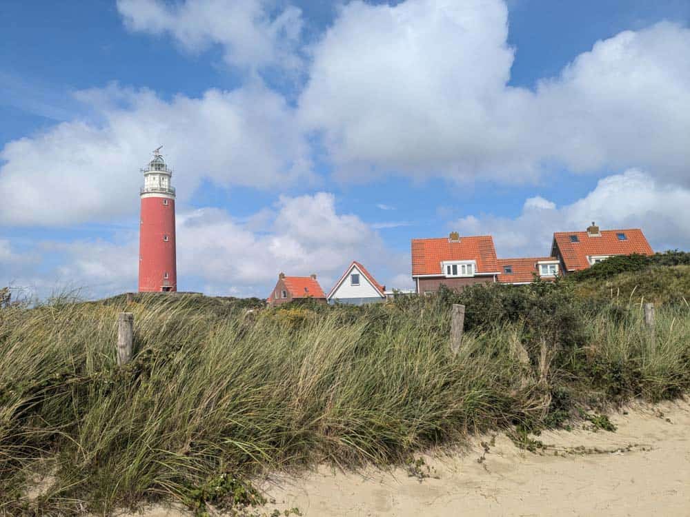 Sand dunes with red lighthouse behind