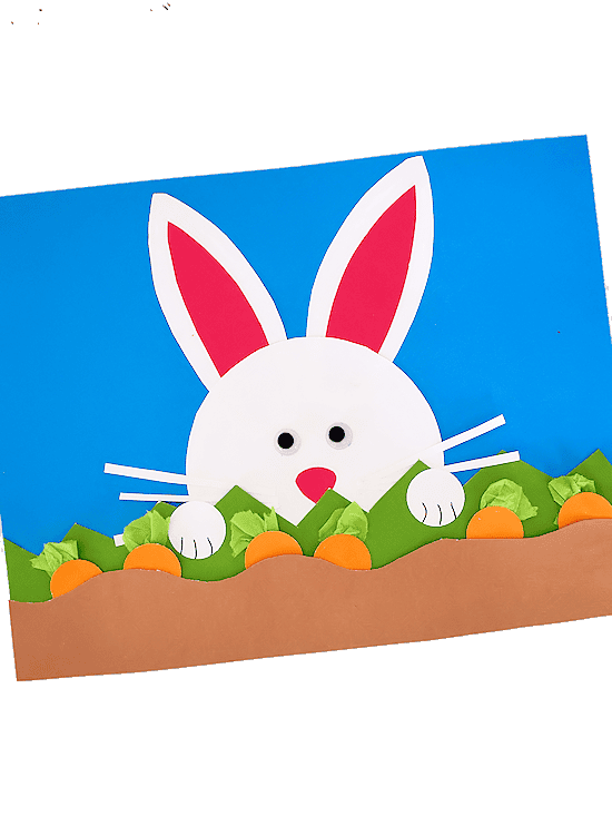 Blue paper with paper carrots and a white bunny