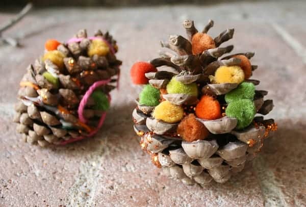 Pinecones with orange and green pompoms stuck in it