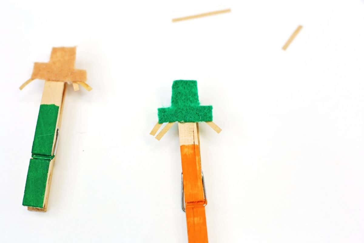 two wooden pegs with felt hats