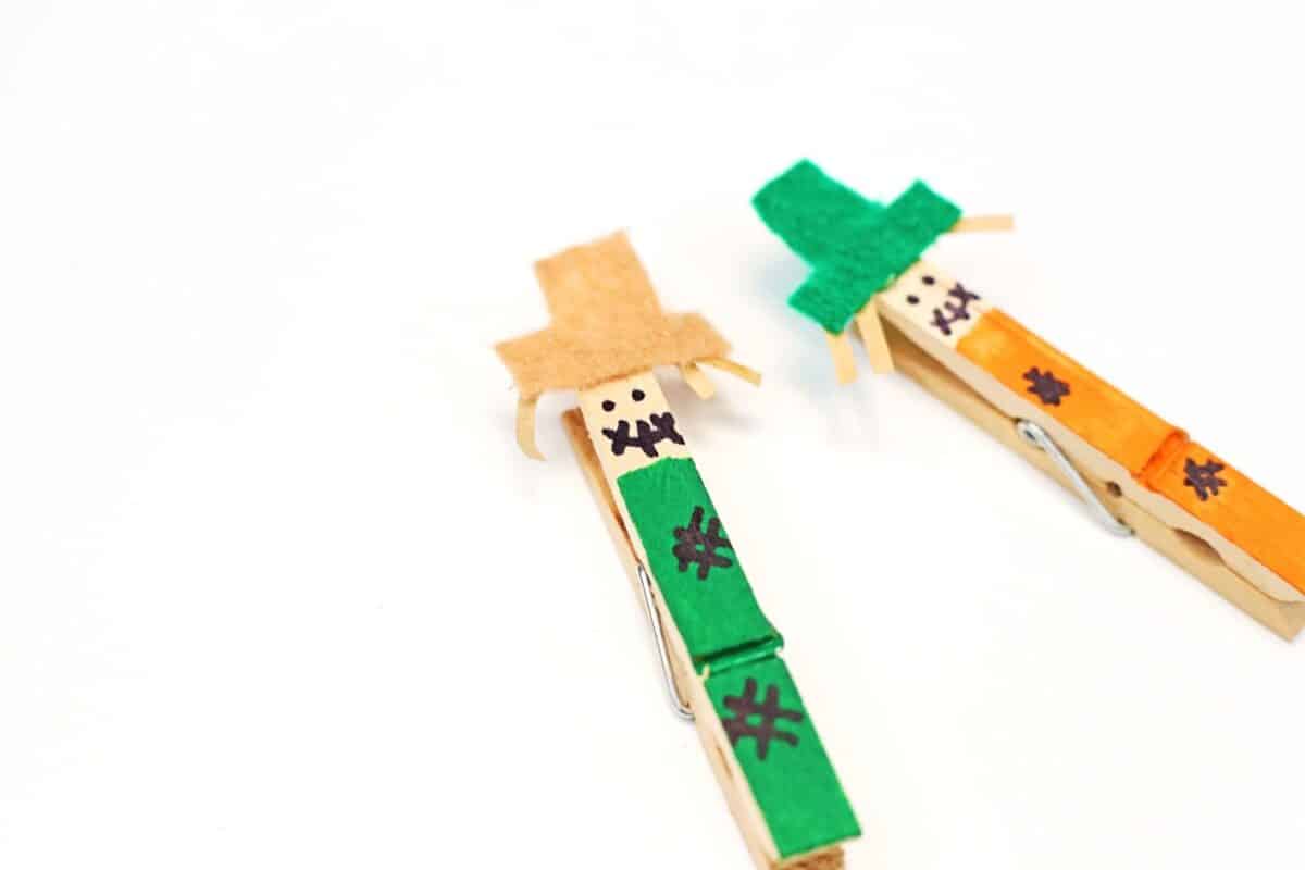 two wooden pegs with felt hats and face details drawn on