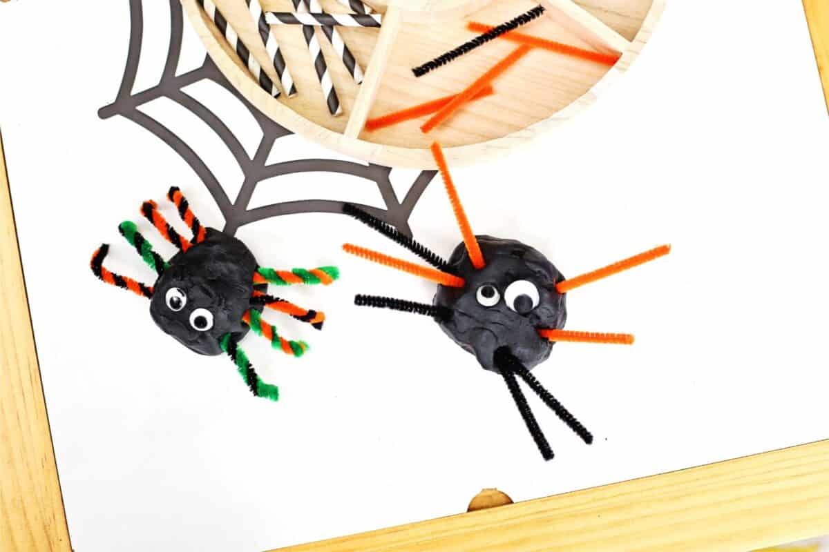 Two spiders made of playdough and pipe cleaners