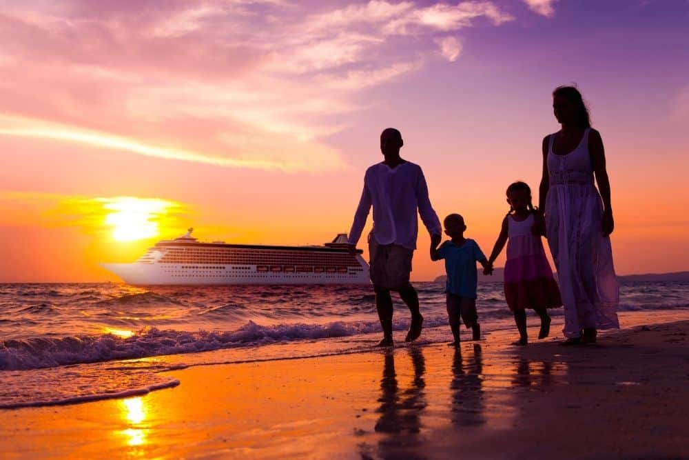 Family of 4 on a beach at sunset with a cruise ship behind