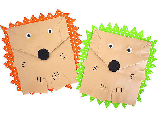 Paper bag hedgehog craft for kids with googly eyes and colorful spiky backing in green and orange.