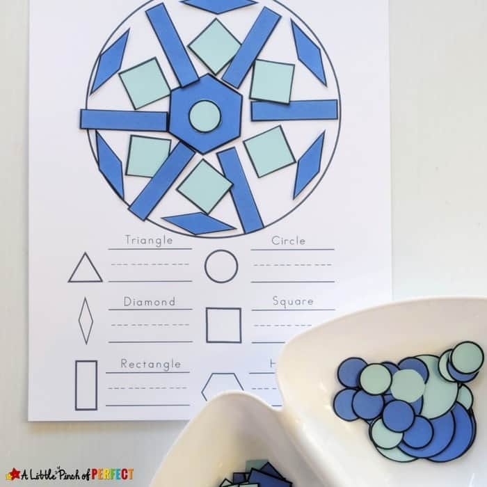Winter-themed shape activity worksheet featuring a circular design filled with colorful paper shapes like triangles, squares, diamonds, rectangles, and circles in shades of blue and green. Two bowls in the foreground hold additional cut-out shapes for matching and sorting.