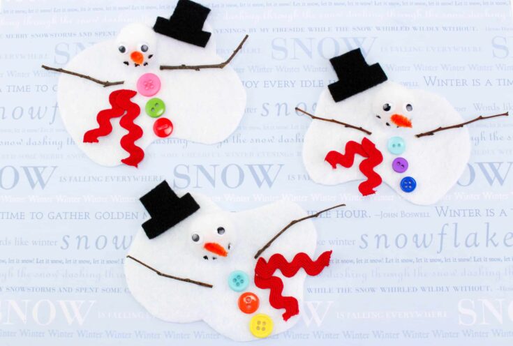 A playful snowman craft made from white felt with colorful button “buttons,” red rickrack scarves, black felt hats, and small twigs for arms. Each snowman face features a pom-pom nose, googly eyes, and drawn-on coal smiles, creating a cheerful winter-themed project for kids.