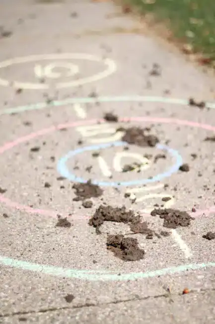 Chalk targets with numbers in drawn on the ground with mud splattered all over it.