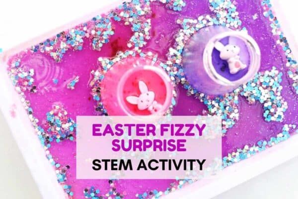 Bright pink and purple sensory bin filled with glitter and two small cups holding bunny figures, creating a colorful Easter fizzy surprise setup. Text overlay reads Easter Fizzy Surprise STEM Activity, highlighting a festive hands on science experiment for kids. The sparkly textures and vibrant colors make the Easter themed STEM activity visually exciting and engaging.